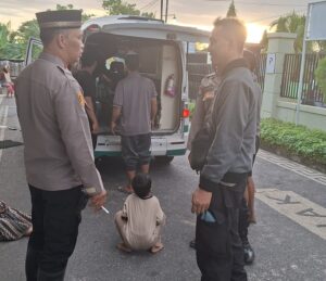 Dua orang polisi sedang mengevakuasi korban yang meninggal dunia saat mencari nyale di Kaliantan menggunakan Ambulans
